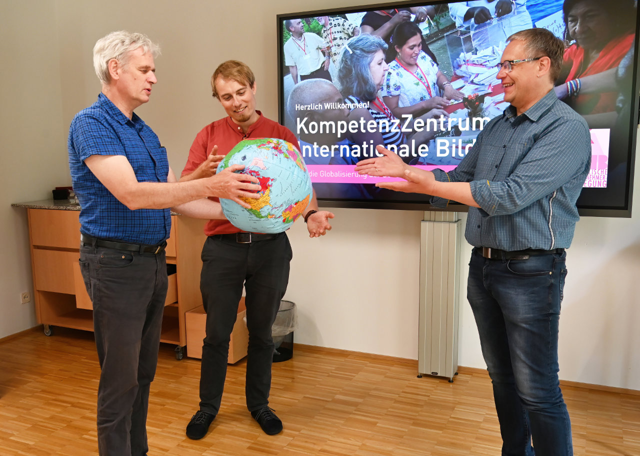 Norbert Jansen, Christoph Holbein-Munske und Andreas Luttmer-Bensmann mit einem Globus in der Hand